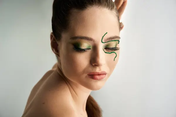 Une belle jeune femme présente un superbe maquillage de serpent dans un studio bien éclairé. — Stock Photo