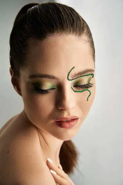 Una bella giovane donna posa con accattivante trucco serpente in un ambiente moderno studio. — Foto stock