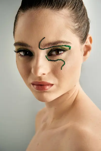 Stunning young woman showcases creative snake makeup artistry in a bright studio environment. — Stock Photo