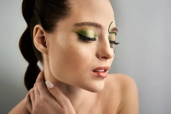 A beautiful young woman showcases intricate snake makeup artistry in a studio environment. — Stock Photo