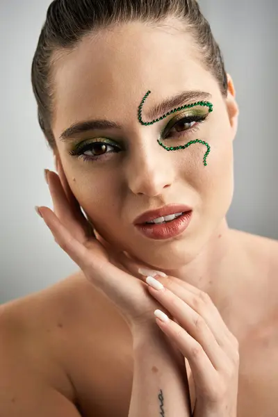 Une belle jeune femme présente un maquillage de serpent accrocheur dans un cadre élégant studio. — Photo de stock