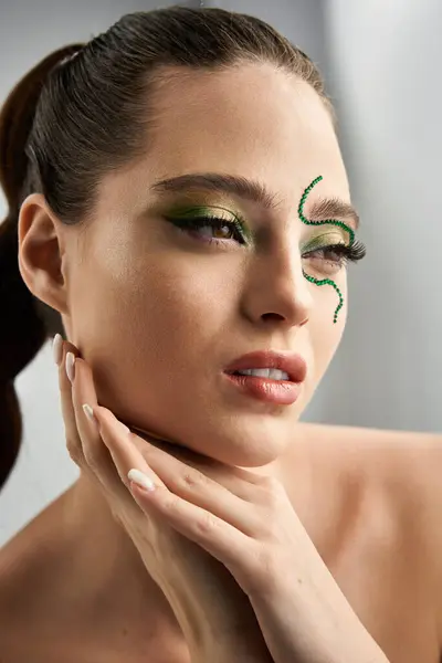 A beautiful young woman poses gracefully, showcasing intricate snake eye makeup. — Stock Photo