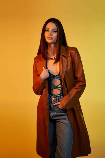 Stunning young woman showcases trendy snake print outfit with bold makeup in a warm setting. — Stock Photo