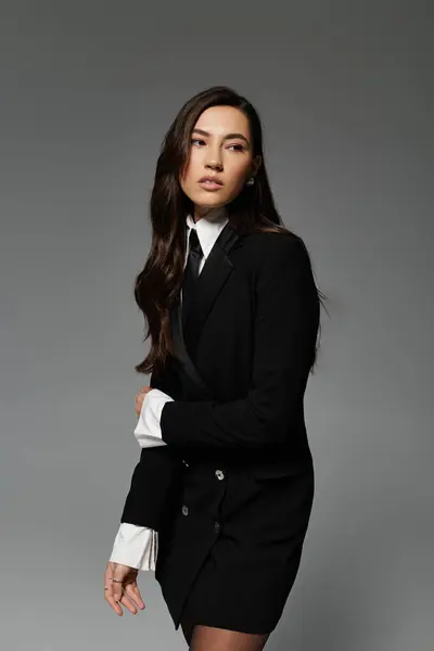 A beautiful young woman with long brown hair showcases her fashion sense in a stylish outfit. — Stock Photo