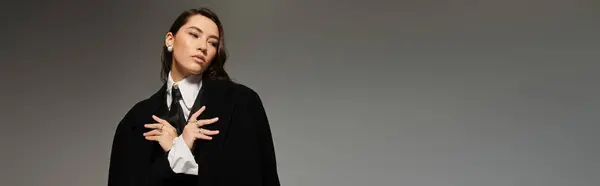 Long-haired woman in stylish outfit poses confidently in a contemporary studio environment, banner — Stock Photo