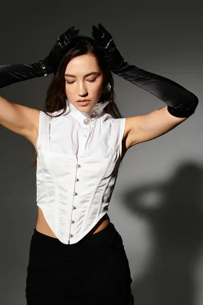 Graceful young woman poses with poise, highlighting her elegant outfit and shiny brown hair. — Stock Photo