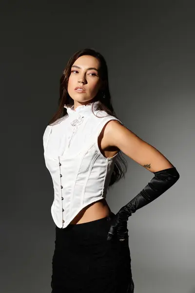 With shiny brown hair, a stylish outfit, and poised elegance, a young woman radiates confidence. — Stock Photo