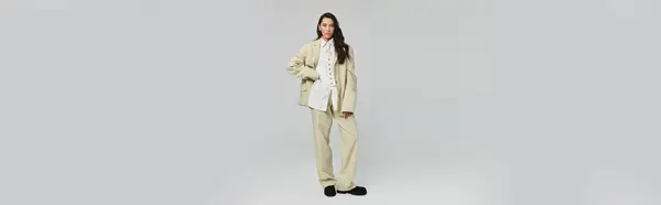 A young woman stands confidently in a stylish outfit, showcasing her unique fashion sense and poise. — Stock Photo