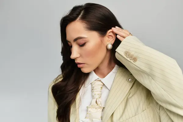 A fashionable woman with long hair elegantly poses, highlighting her stylish outfit and accessories. — Stock Photo