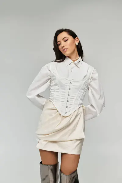 Young woman exudes charm wearing a chic outfit, striking a pose with an air of confidence. — Stock Photo