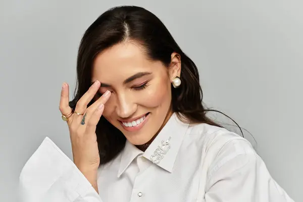 A young, beautiful woman exudes charm while playfully touching her face, radiating happiness. — Stock Photo