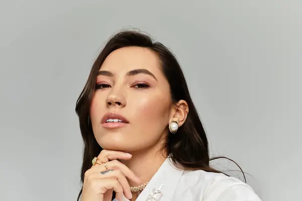 A young woman showcases her beauty and style with a thoughtful pose against a minimalist backdrop. — Stock Photo