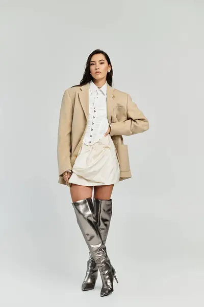 Confident woman showcases a trendy outfit featuring an oversized blazer and shiny accessories. — Stock Photo