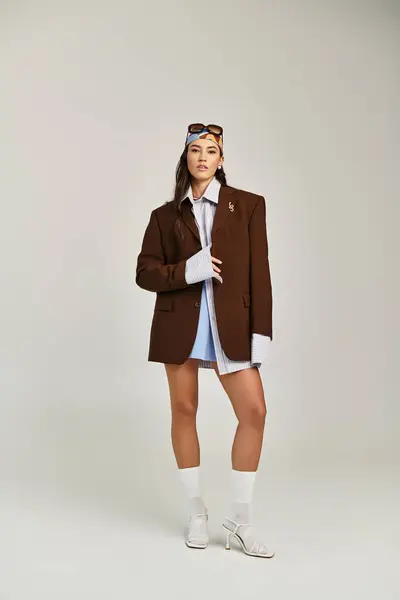 A young woman flaunts her style in a chic oversized blazer and trendy accessories. — Stock Photo