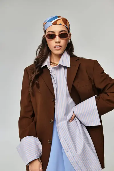 Una mujer de moda en un traje elegante exuda estilo y elegancia mientras posa con confianza. - foto de stock