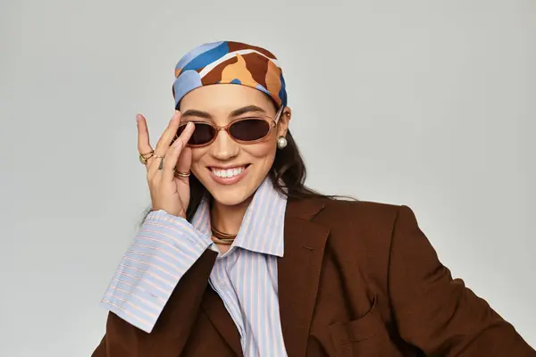 In a chic studio setting, a beautiful woman showcases her unique style while posing gracefully. — Stock Photo