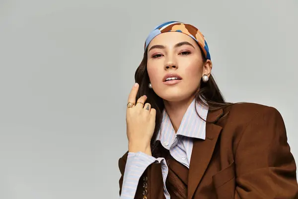 A beautiful woman displayed her unique style with a fashionable headscarf and oversized blazer. — Stock Photo