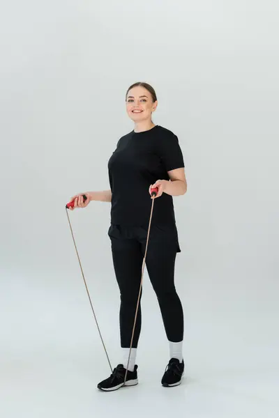 Una mujer en forma se prepara para un entrenamiento con bandas de resistencia, mostrando fuerza y determinación. - foto de stock
