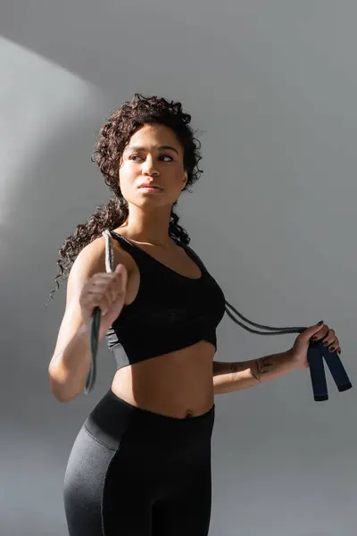 A determined woman trains with resistance bands in a modern gym, showcasing her strength. — Stockfoto