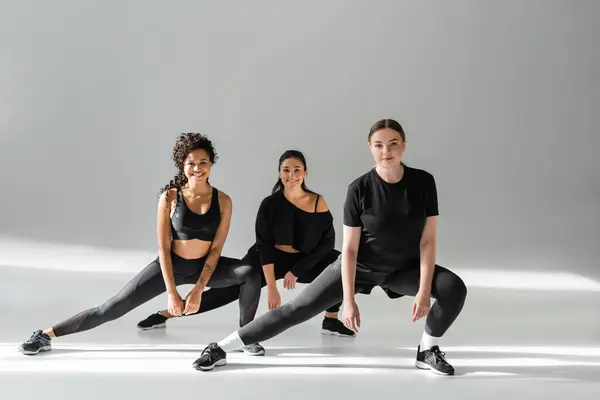 Tres mujeres fuertes participan en una rutina de fitness, mostrando su dedicación y atletismo. - foto de stock