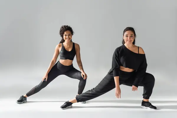 Two women engage in a powerful fitness routine, demonstrating strength and focus during practice. — Stock Photo