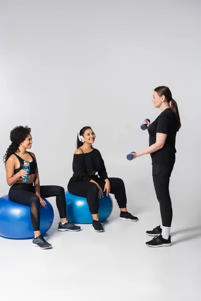 Tre donne forti e in forma si motivano a vicenda durante una sessione di allenamento in una palestra. — Foto stock