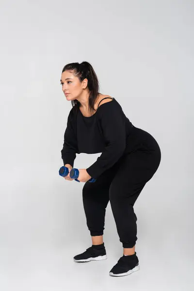Fit female engaged in a strength training workout while showcasing determination and power — Stock Photo