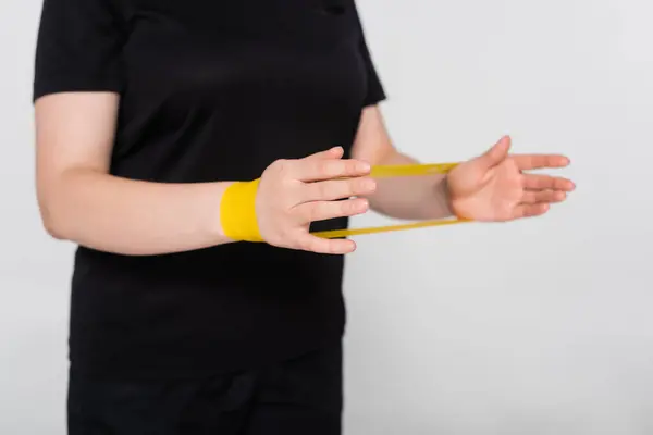 Strong female engages in an empowering workout using a resistance band for strength training. — Stock Photo