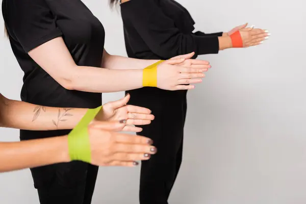 Three women perform a resistance band exercise, demonstrating strength and teamwork in fitness. — Stock Photo