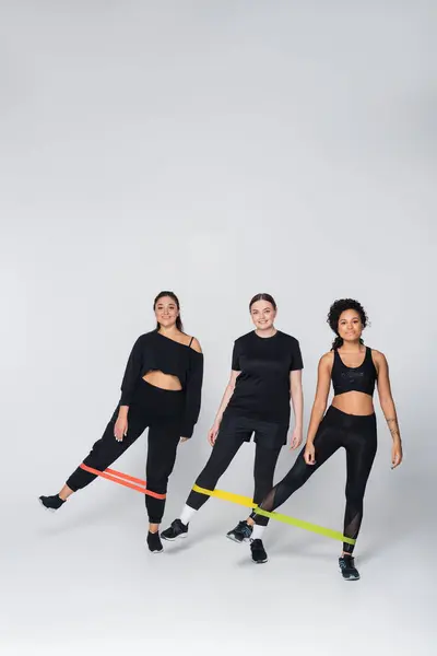 Women demonstrate strength and teamwork while using resistance bands for an energized workout. — стоковое фото