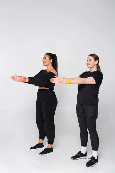 Two fit women work on their fitness routines with confidence while showcasing their athletic wear. — Stock Photo