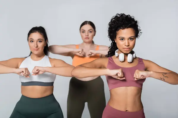 Drei starke Frauen betreiben eine dynamische Fitness-Routine, die gemeinsam Stärke und Selbstvertrauen verkörpert. — Stockfoto