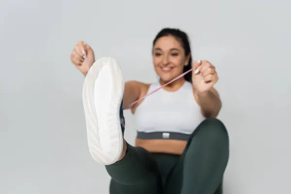 A determined woman uses a resistance band to boost her strength and fitness routine. — Stock Photo