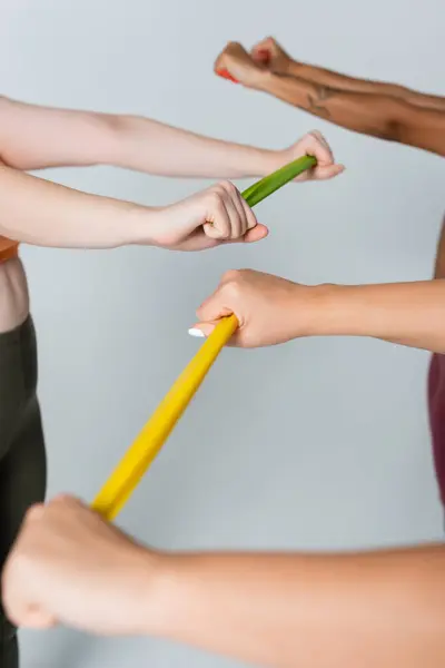 Women work together using resistance bands, showcasing strength and teamwork in a fitness studio. — Stock Photo