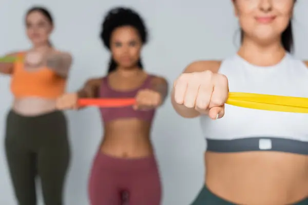 Fit women bond while exercising with resistance bands for strength and endurance. — Stock Photo