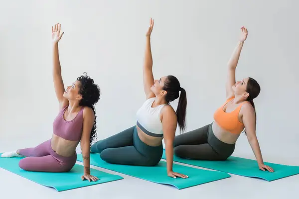 Women perform an uplifting fitness routine on mats, showcasing strength, beauty, and unity. — Stock Photo