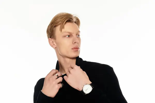 Красивий молодий чоловік налаштовує свій комір, демонструючи сучасний стиль з елегантністю і чуттям. — Stock Photo