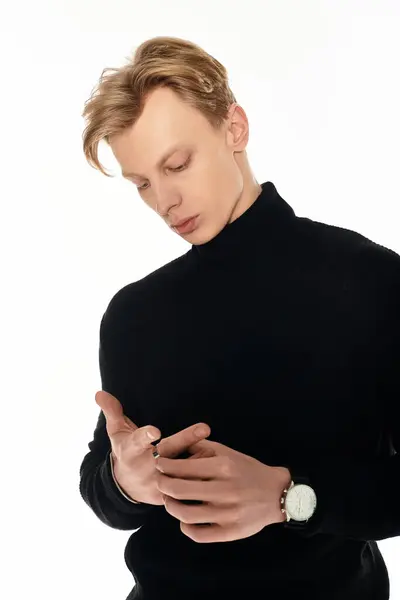 A young man in a stylish black turtleneck stands thoughtfully, exuding elegance. — Stock Photo