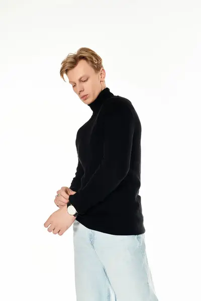 A young man with a trendy look adjusts his watch, showcasing his fashionable style and confidence. — Stock Photo