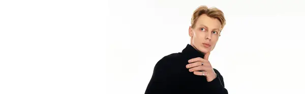 Young man with bold features poses thoughtfully in an elegant studio, radiating confidence. — Stock Photo