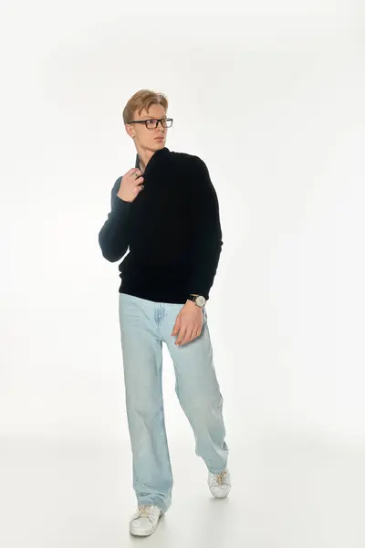 A young handsome man walks with confidence, dressed in casual clothing against a bright backdrop. — Stock Photo