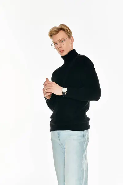 Ein junger, gutaussehender Mann mit schwarzem Pullover steht selbstbewusst da und strahlt Stil und Charme aus.. — Stockfoto