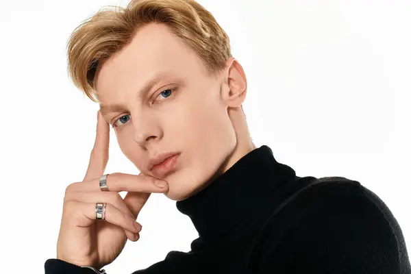 A young man with striking features contemplates while showcasing his cool style in a studio. — Stock Photo