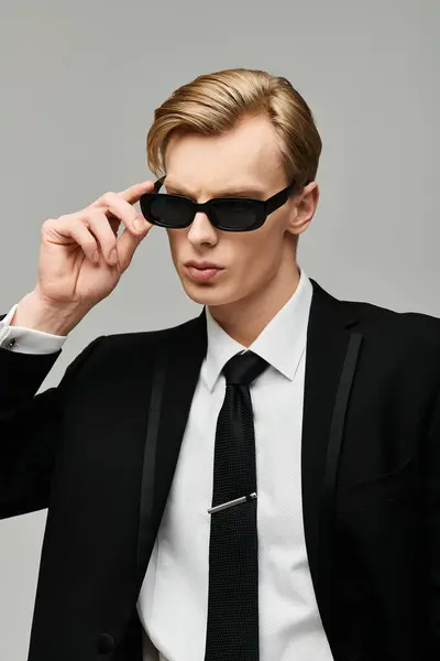 A young man exudes charisma while wearing a tailored suit and sleek sunglasses ready for an event. — Stock Photo