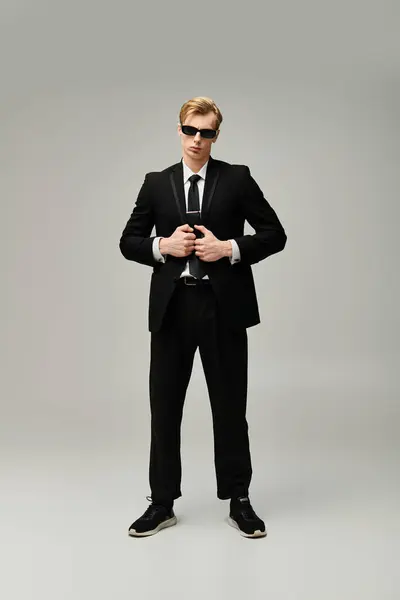 Sporting sunglasses and a tailored suit, this young man exudes confidence while standing tall. — Stock Photo