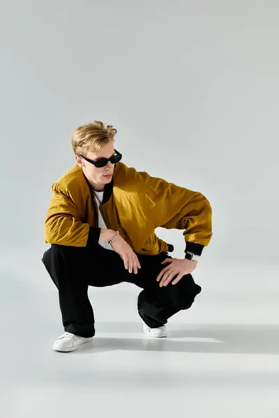 Young man showcases a trendy outfit while striking a confident pose in a minimalist environment. — Stock Photo