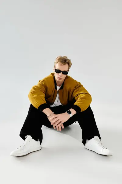 A handsome young man reclines confidently on the floor, showcasing modern style and attitude. — Stock Photo