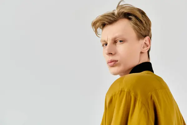 Young man with striking features looks back confidently, showcasing his unique style and flair. — Stock Photo