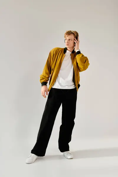 A young man models a stylish jacket and modern black pants with elegance. — Stock Photo