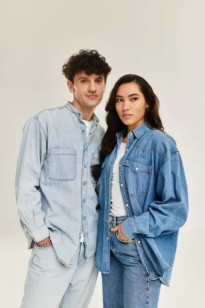 Fashionable young couple poses together in matching denim outfits, exuding confidence and style. — Stock Photo